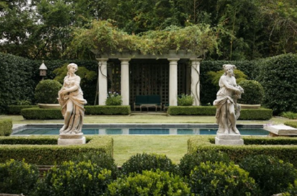 Taman klasik dengan pohon-pohon tinggi dan patung-patung klasik